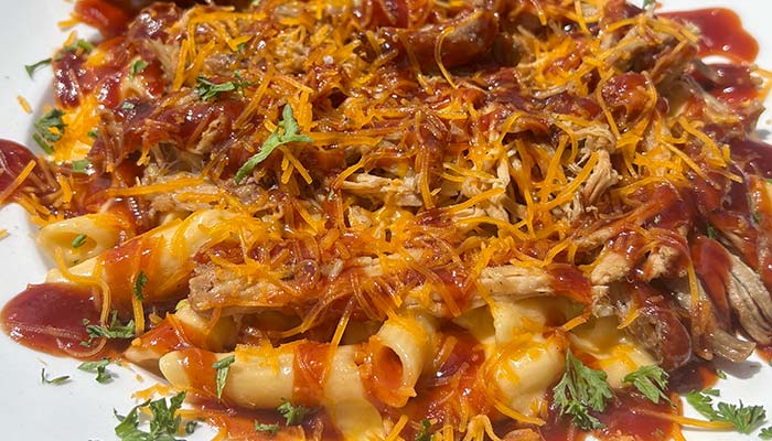 Pasta topped with shredded meat, barbecue sauce, and cheese at a Montrose Minnesota restaurant.