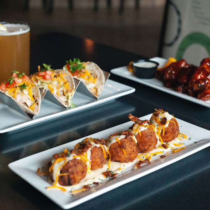 Three tacos, wings, and cheesy potato balls at Jacque B's Kitchen & Cocktails Bar & Grill.