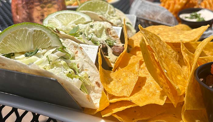 Tacos with lime and lettuce served with tortilla chips at Jacque B's Kitchen & Cocktails.