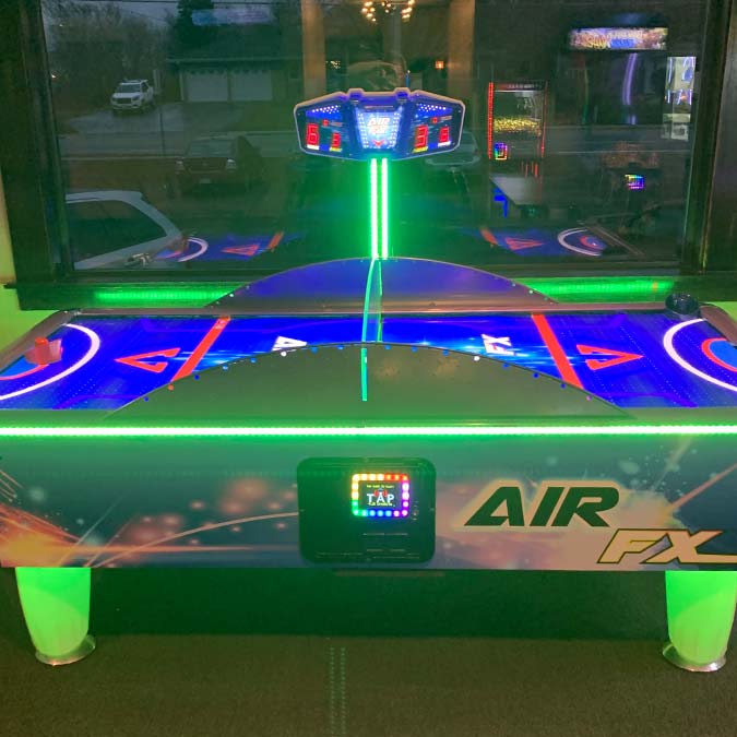 Air hockey table with LED lights at Jacque B's Kitchen & Cocktails, inside the arcade.
